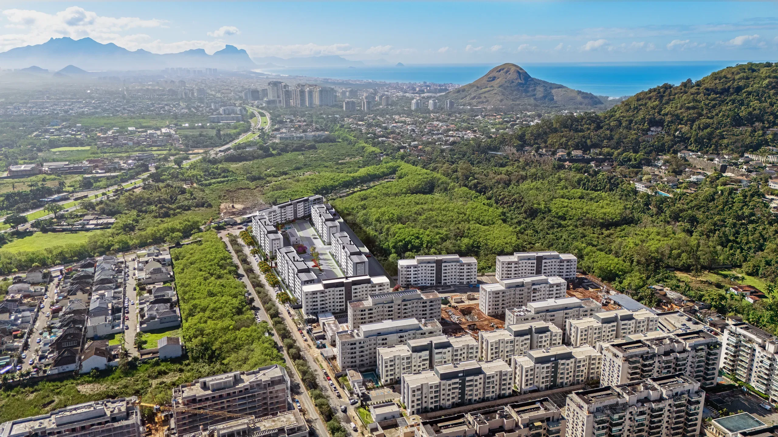 Vista aérea do terreno do Atlântico Recreio, com o mar e o morro ao fundo, imagem ilustrativa